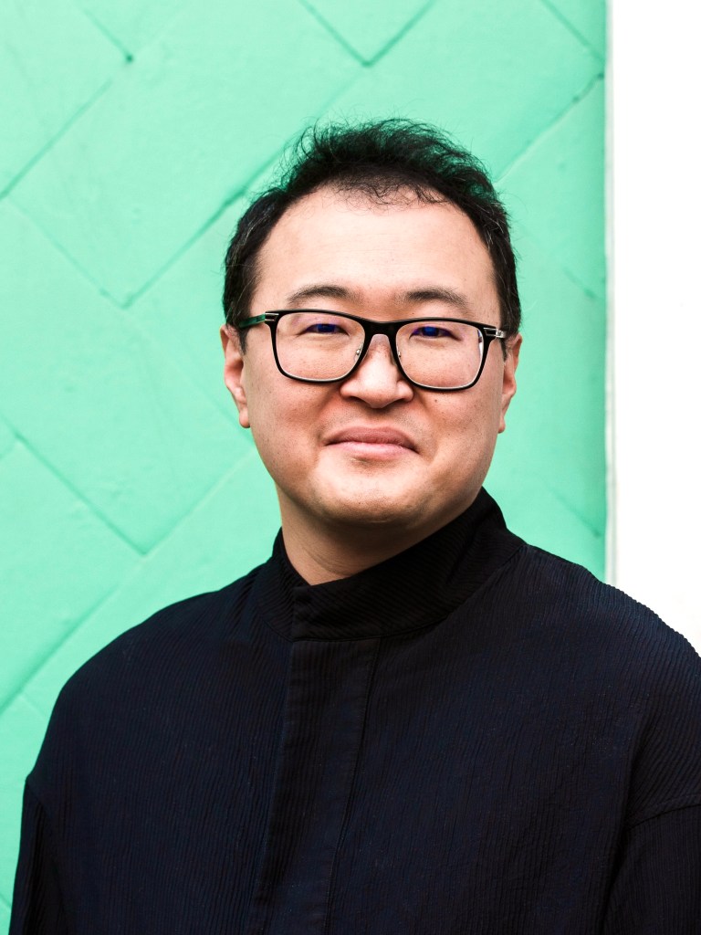 author photo of Asian man in glasses with black shirt